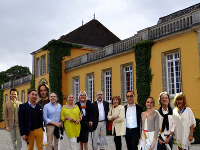 groupe de gens collés devant un château jaune